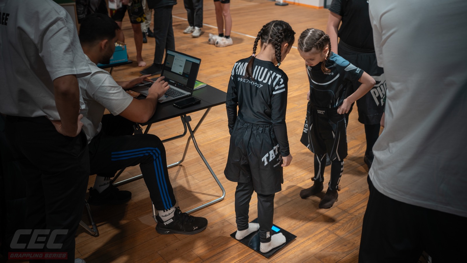 Wiegen bei Grappling Series 2 — eine Jugendstarterin auf der Waage, das Ergebnis wandert direkt in den Laptop am Tisch