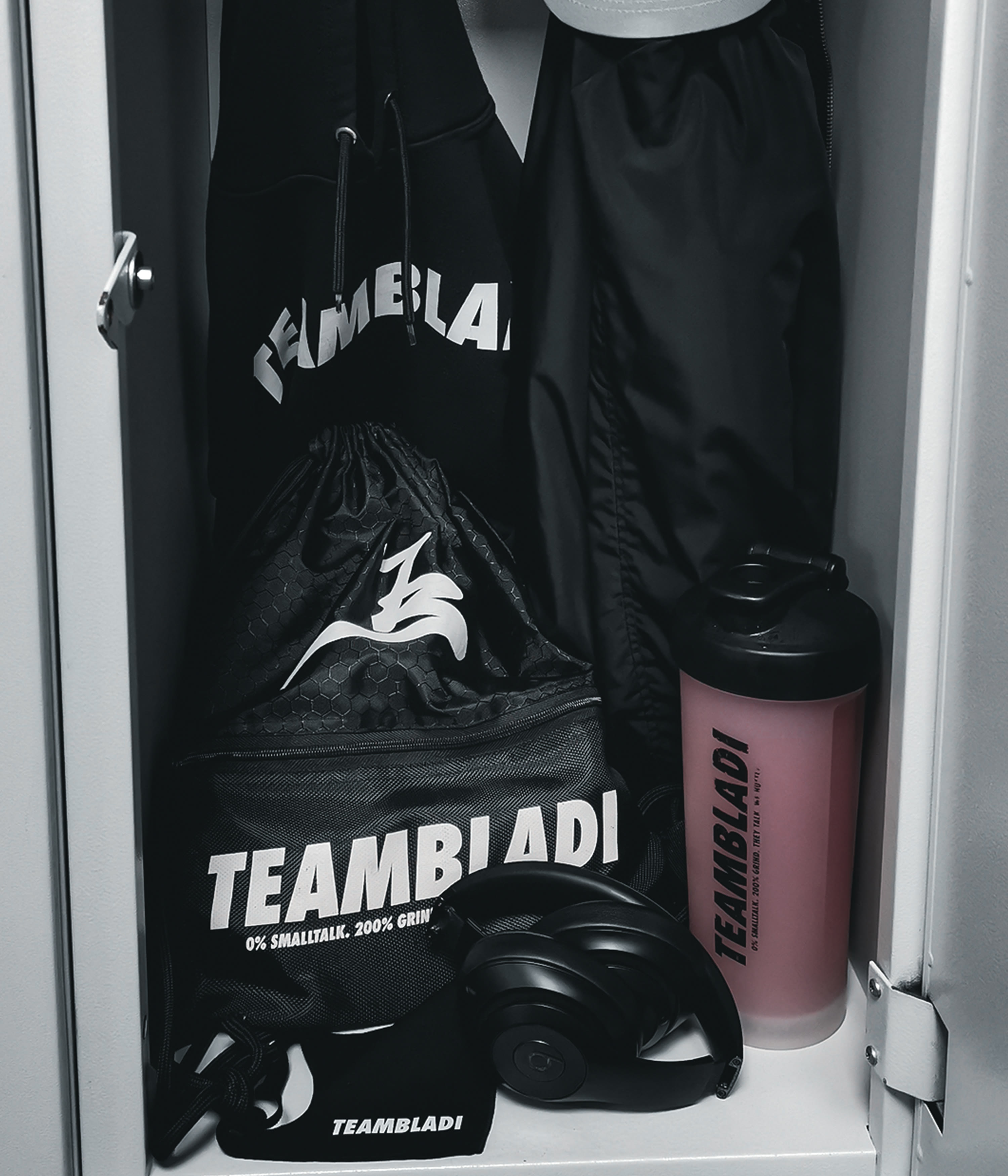 TEAMBLADI Gear-Flatlay — Hoodie, Tasche, Trinkflasche und Kopfhörer in einem Umkleidespind